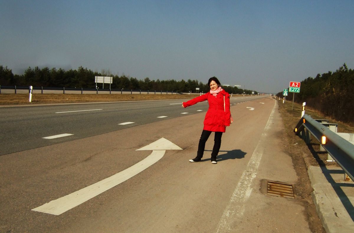 Bright clothes make it easier to be seen from a distance, which is especially necessary when hitchhiking directly on a motorway, as here in Lithuania.