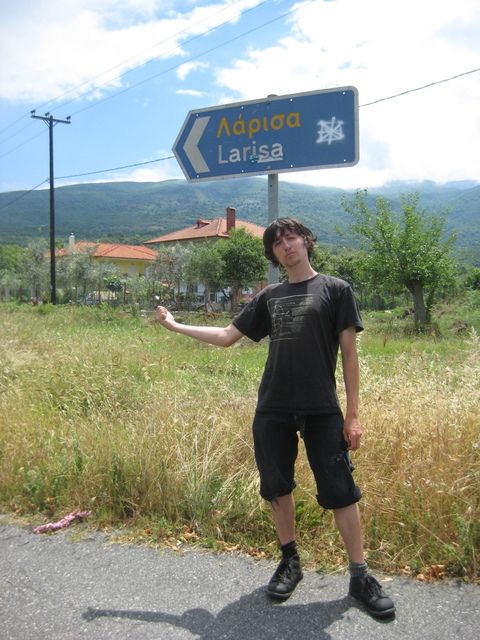 Hitchhiker Jass thumbing in Greece, June 2008. His hips have seemingly turned inside out.